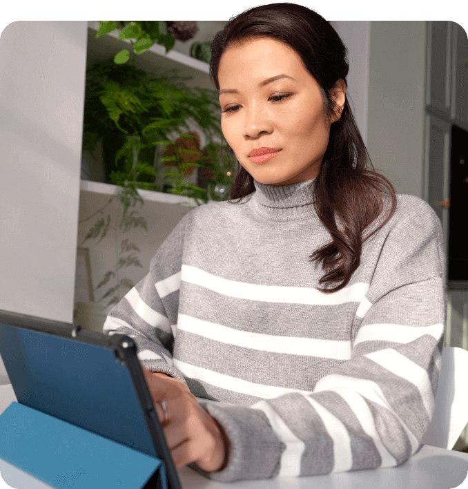 A woman in a striped jumper starling at a tablet device.