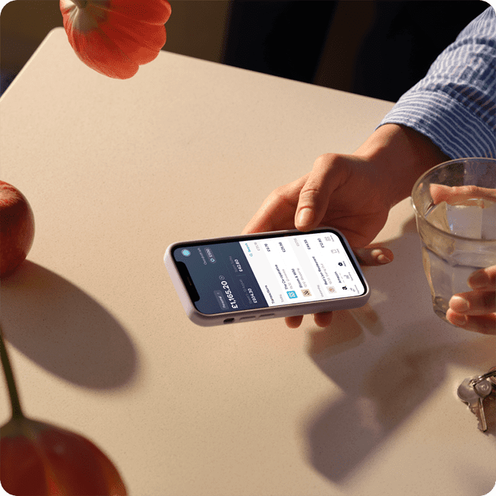 A phone in the hands with the homescreen of the Starling Bank mobile app