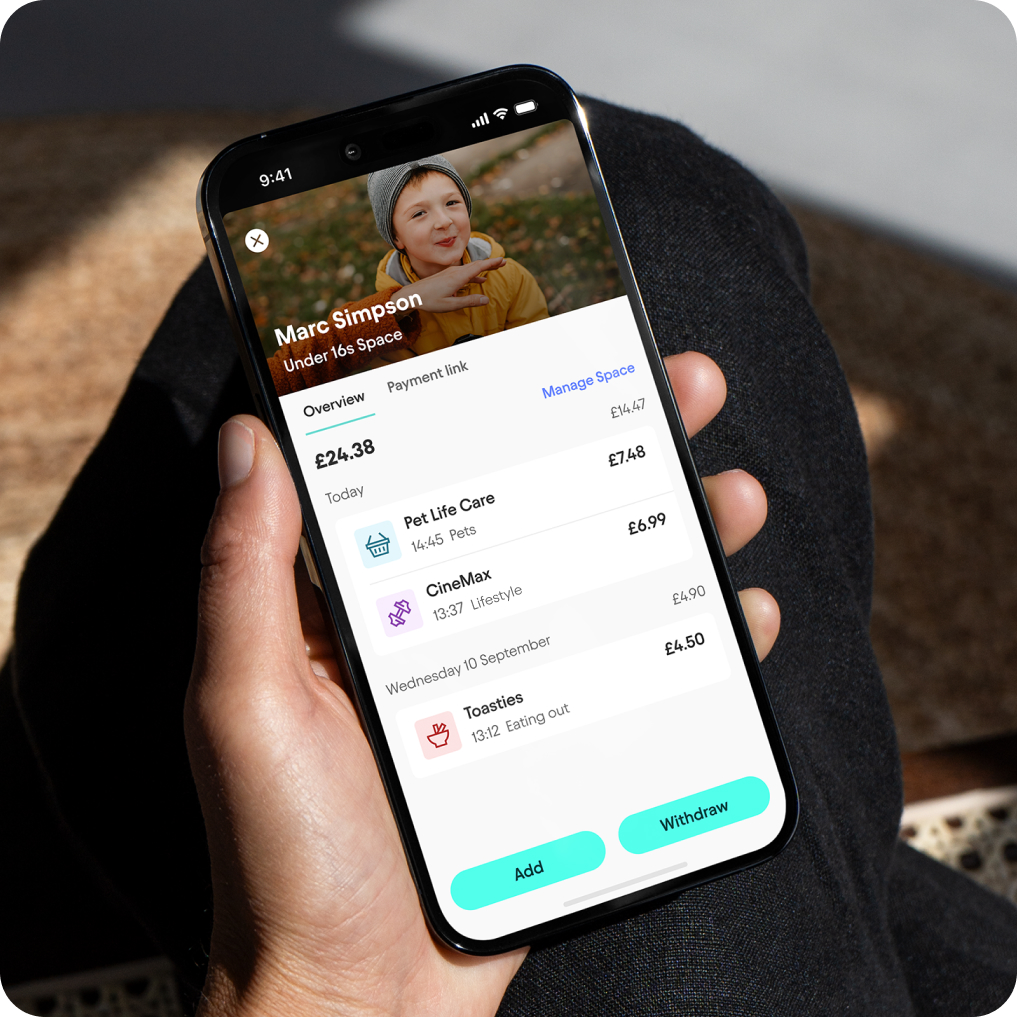Hand holding phone showing Under 16s Space in Starling app, with an overview of spending