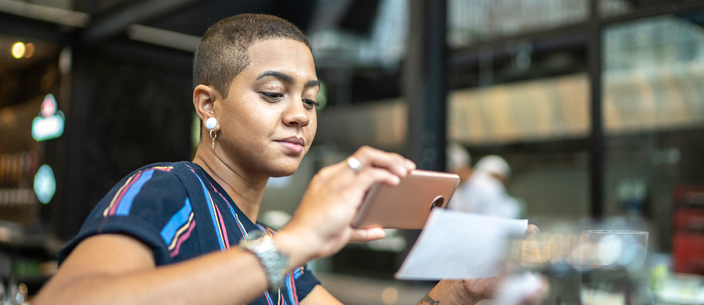 Person taking a photo of a cheque to pay in via the app