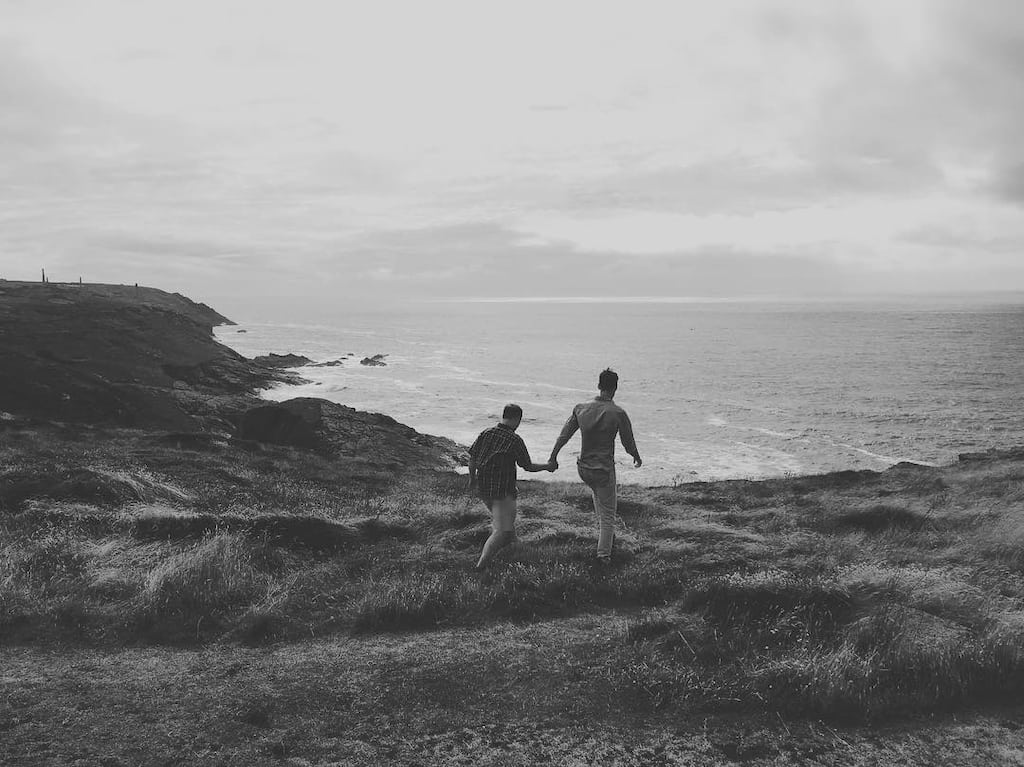 Two people walking over some cliffs