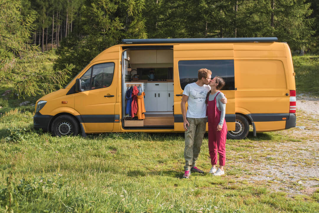 Campervan with couple standing outside