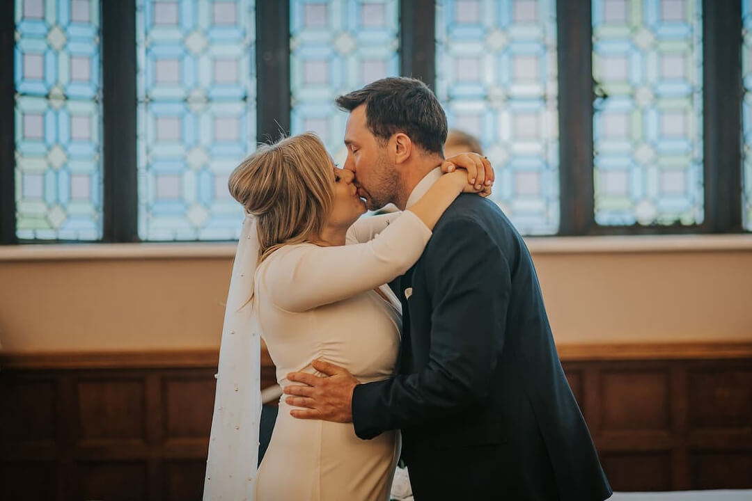 A couple kiss in a church on their wedding day