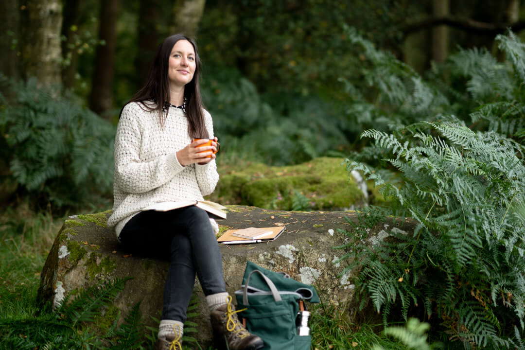 Woman sitting on a rock with a backpack