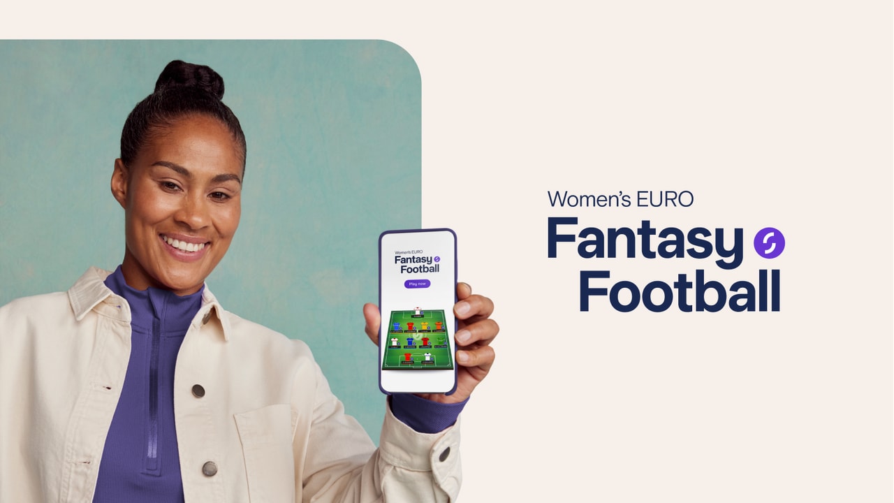 Rachel Yankey holding a phone with the Women's EURO Fantasy Football app open