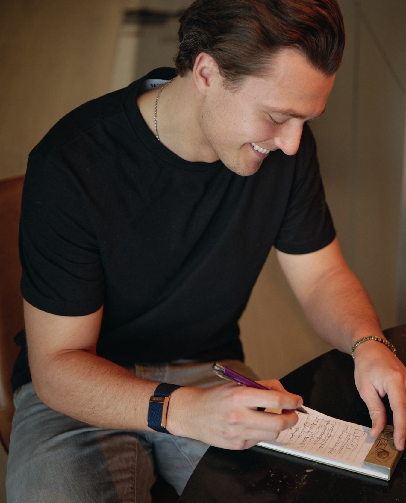 A man writing a shopping list with a pen