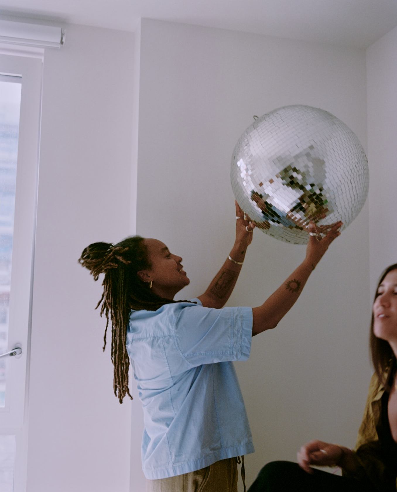 A woman is holding disco ball