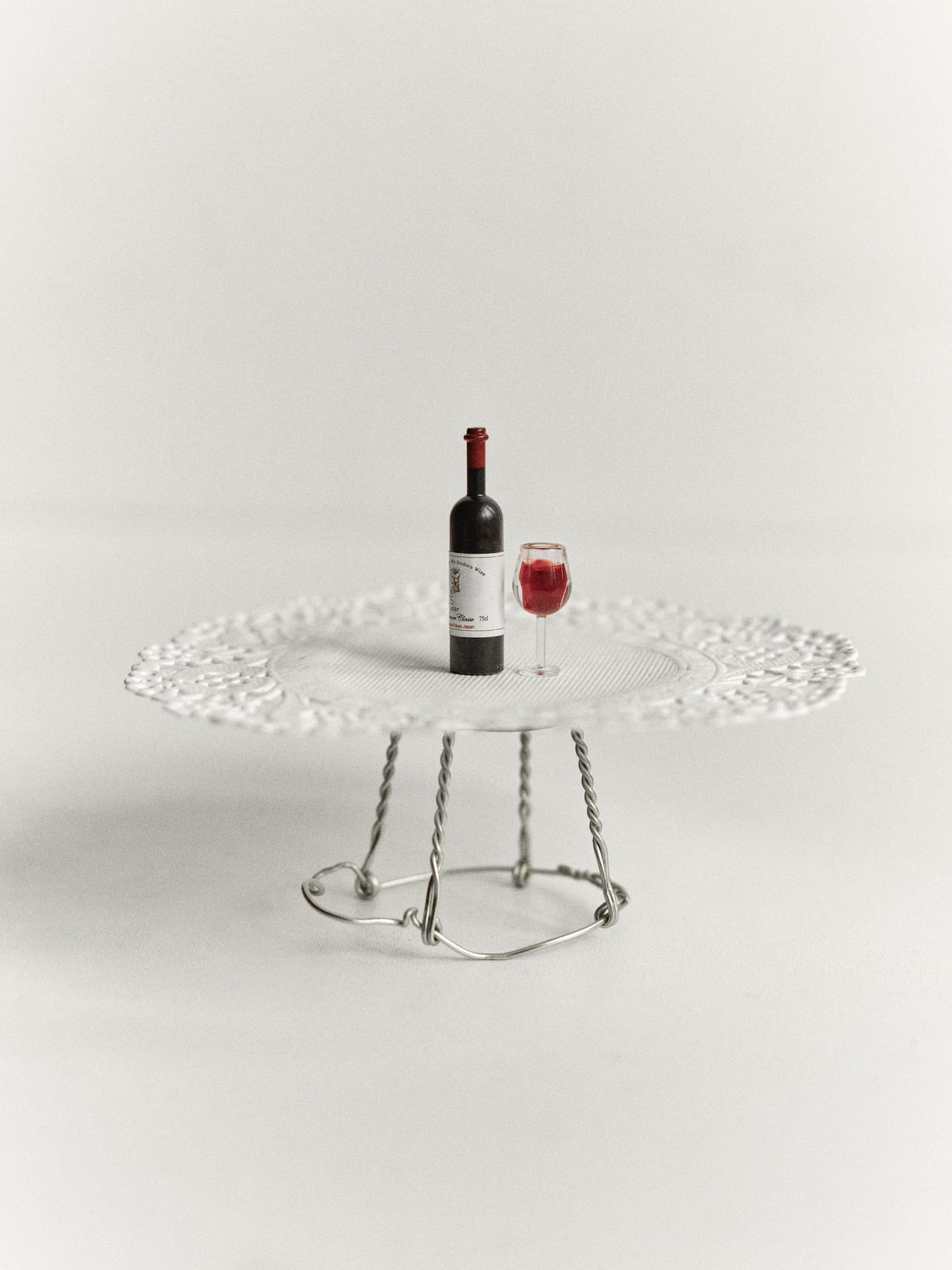 Miniature wine bottle and glass on a table