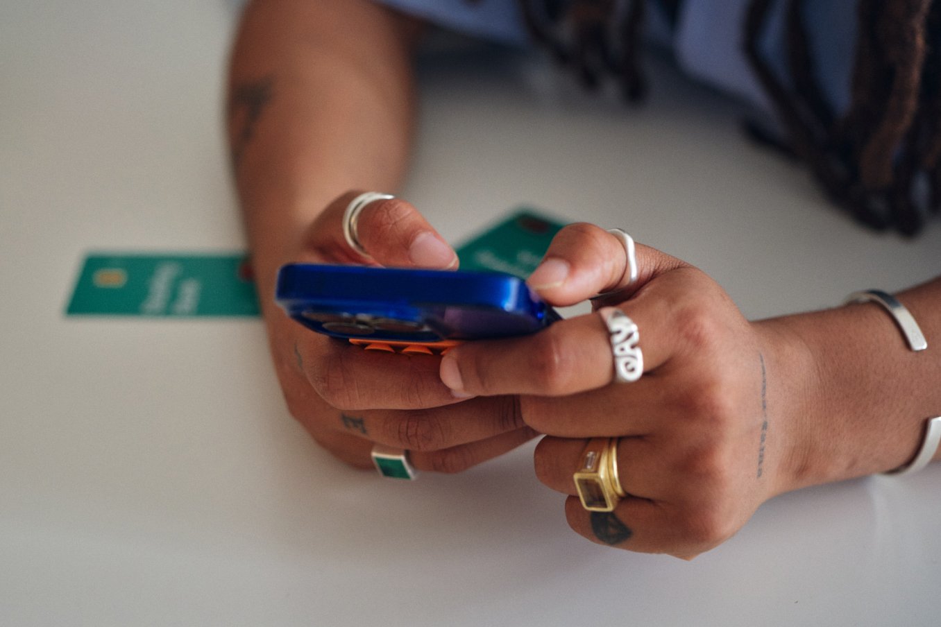 Close up of hands with a phone with Joint Account Starling bank card on the background