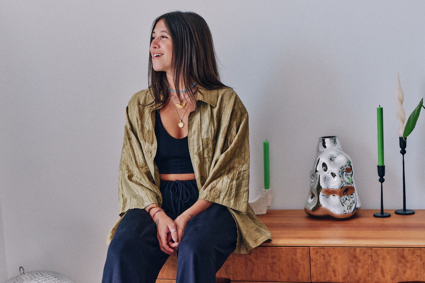 A woman is sitting on the desk and smiling