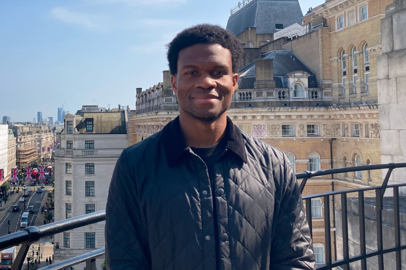 Headshot of Timi Merriman-Johnson on a balcony in London