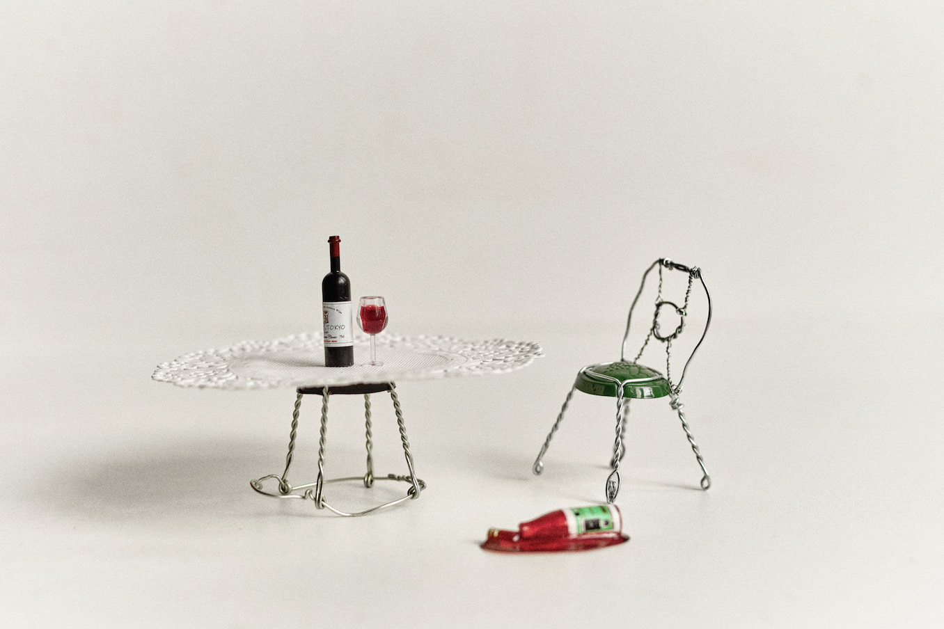 A table and chair with a miniature bottle of wine and glass