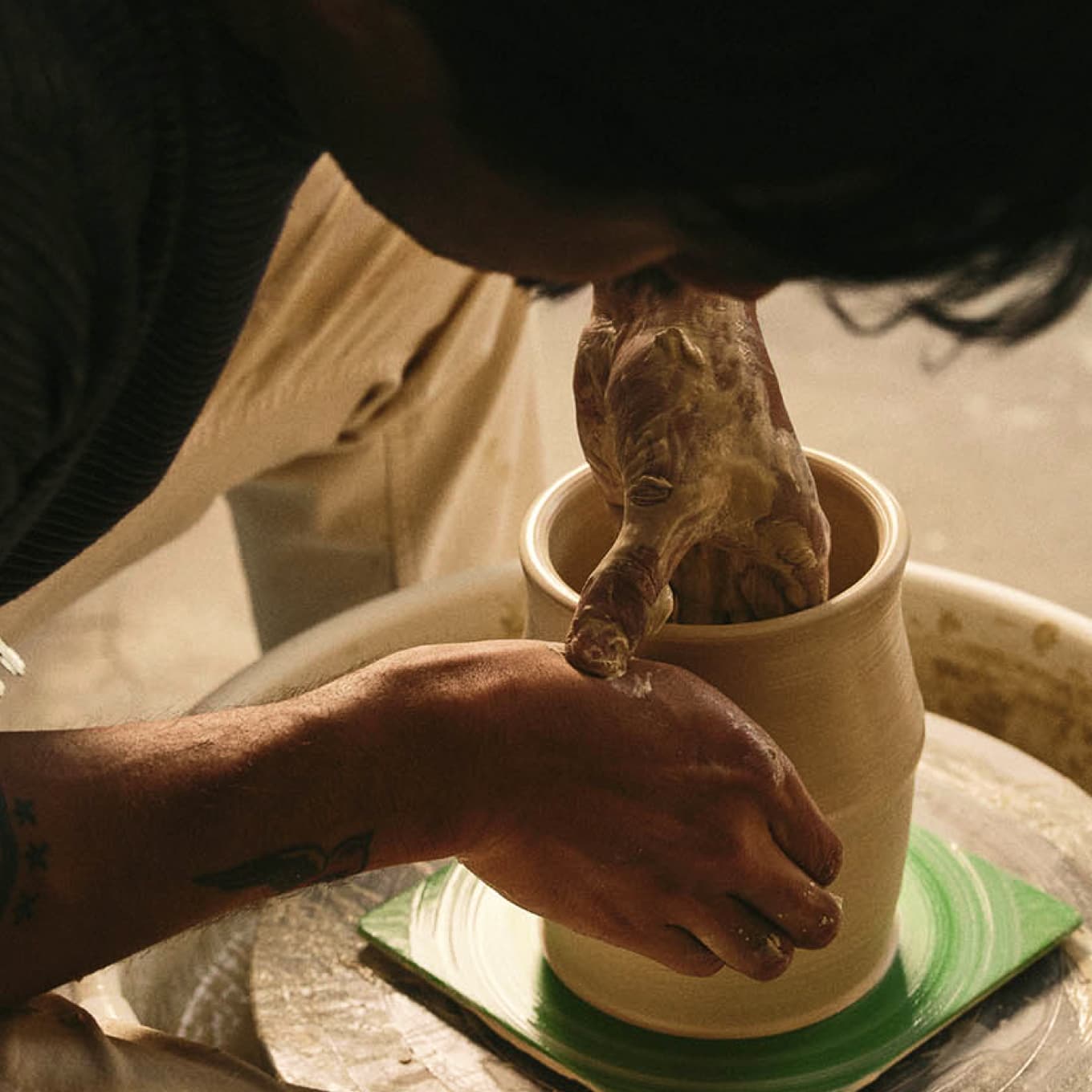 Man making a vase on pottery wheel
