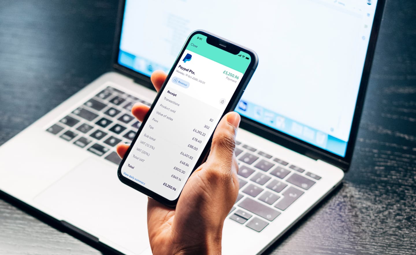 A hands holds a phone showing the Zettle interface on the screen