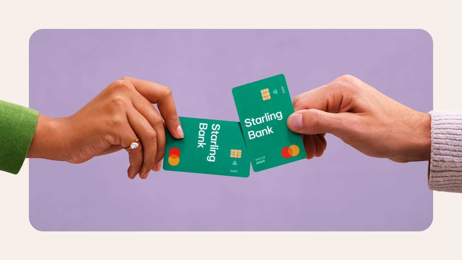 two peoples' hands holding Starling bank cards together