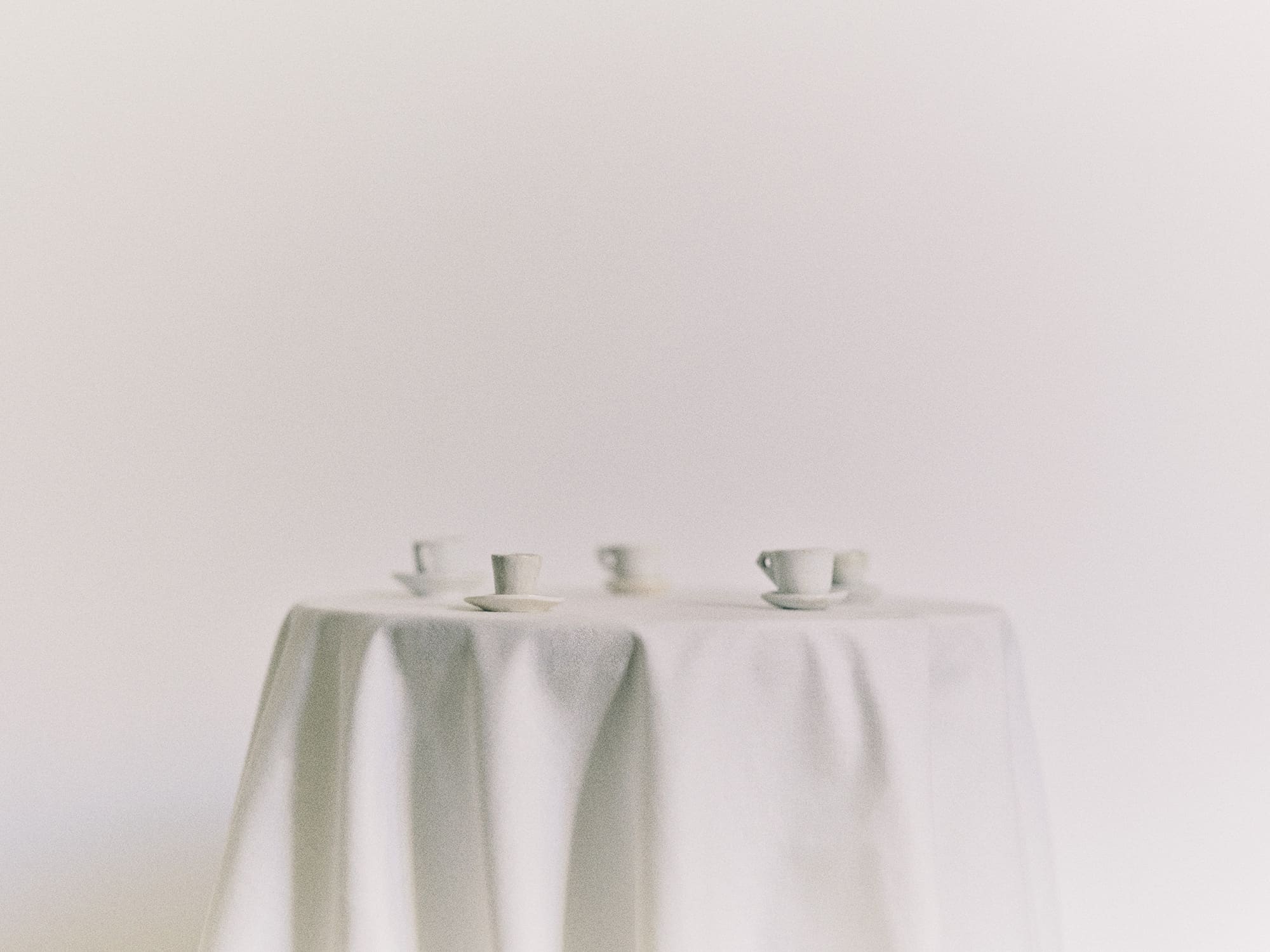 Miniature teacups on a white tablecloth