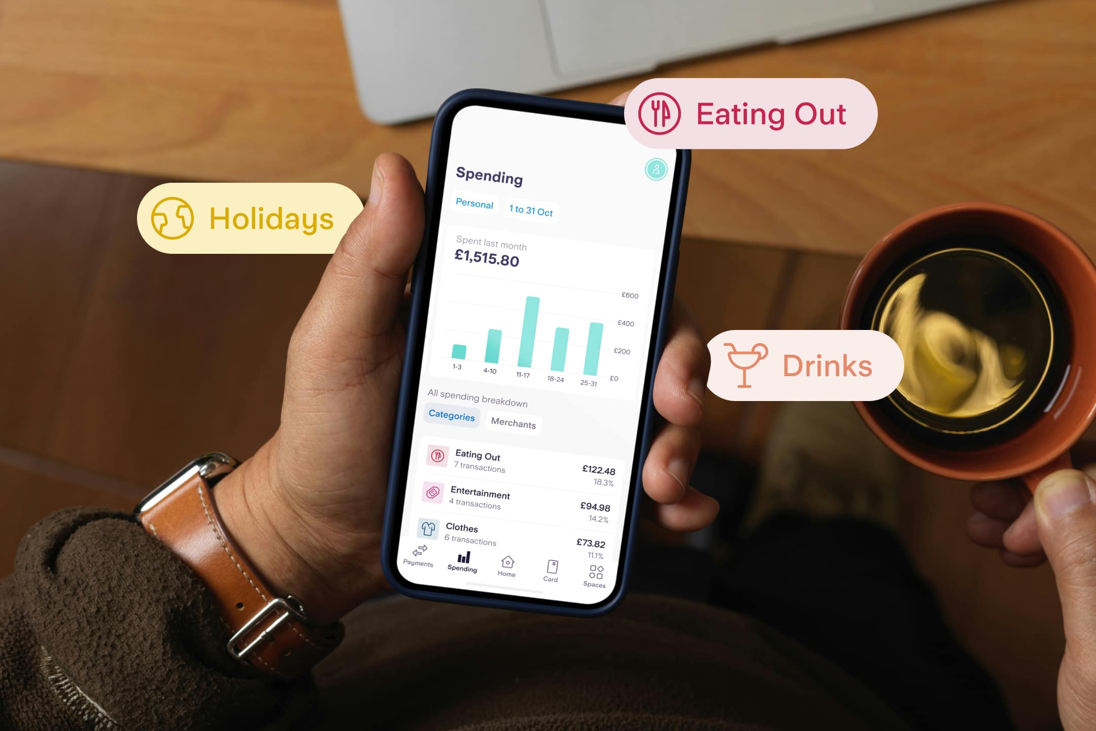 Person holding their phone looking at the Spending Insights tab of their phone with the categories Eating Out, Drinks and Holidays highlighted.