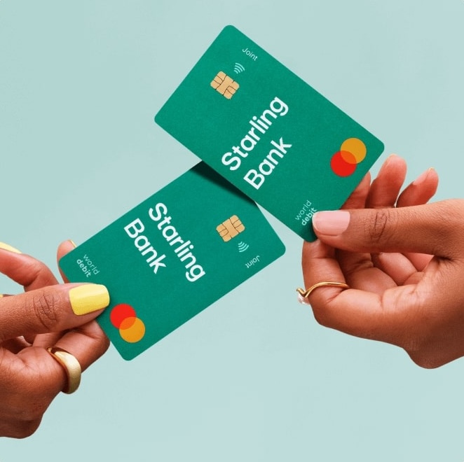 Two hands, each holding a Starling Bank joint account card