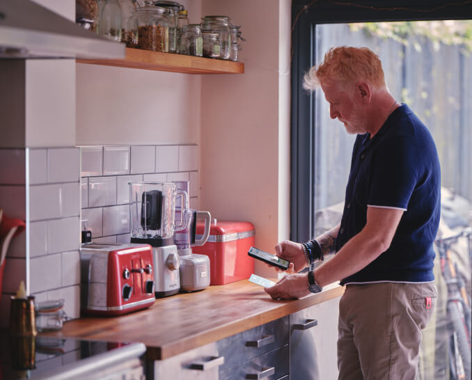 man-in-kitchen-looking-at-phone