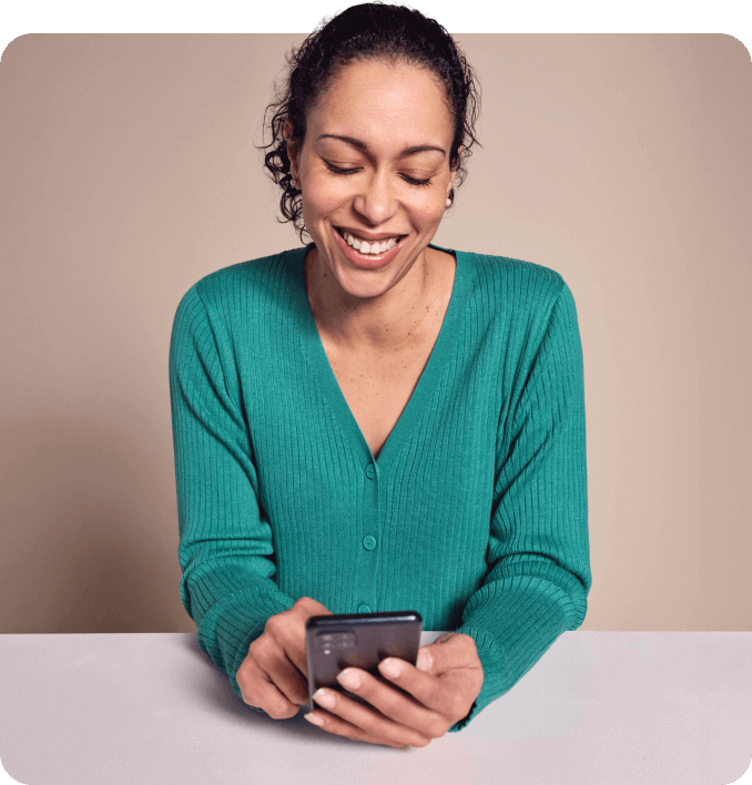 Woman looking down at phone smiling