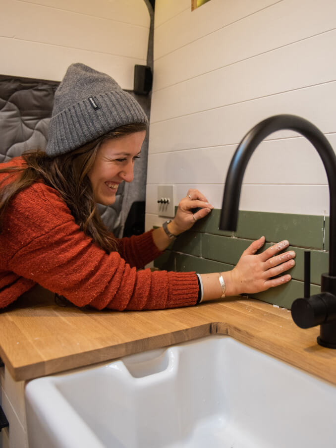 woman placing tiles in her campervan