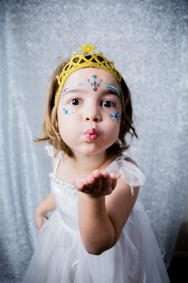 Aina’s daughter wears a crown and glitter